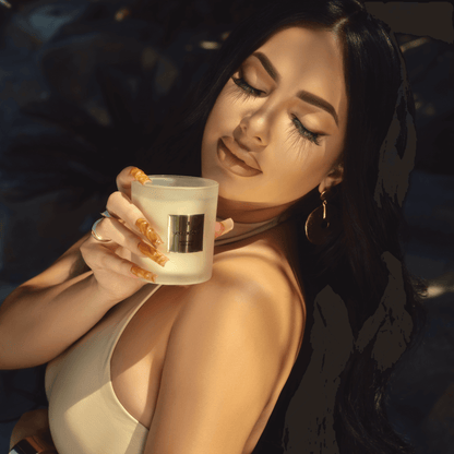 Briana Murillo delicately holds the Second Self Scented Candle close to her face, inhaling its fragrance from Murillo Twins Fragrance.