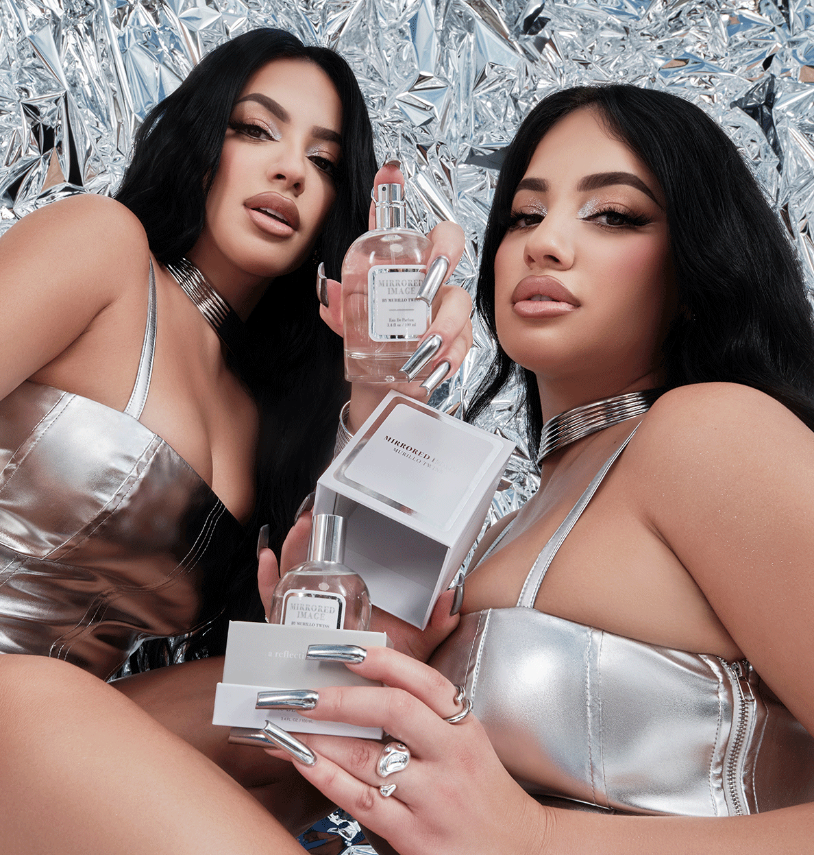 Brittany and Briana Murillo each posing with the 3.4 fl oz Mirrored Image fragrance.