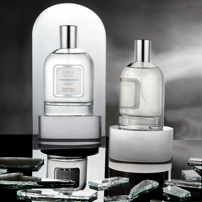 The Mirrored Image fragrance from Murillo Twins Fragrance displayed on a pedestal, with a mirror in front of it, capturing its reflection.