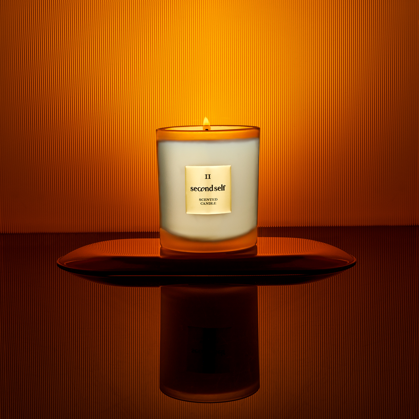 The Second Self candle from the Second Self Collection displayed on a pedestal, set against a backdrop with an ombre effect.