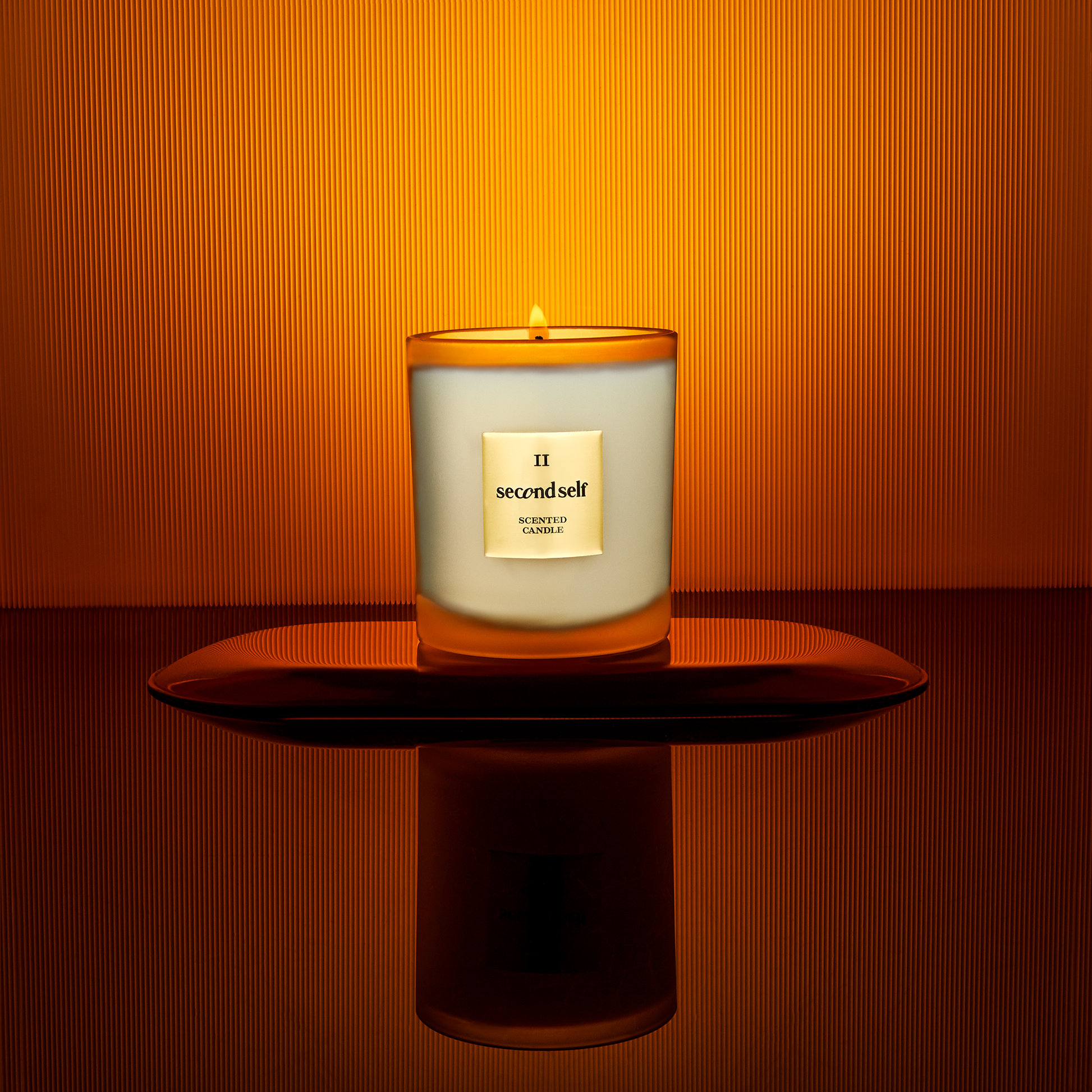 The Second Self candle from the Second Self Collection displayed on a pedestal, set against a backdrop with an ombre effect.